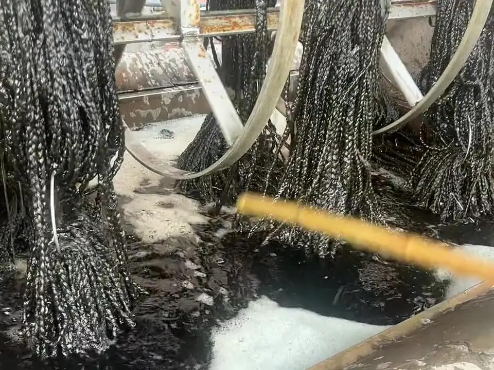 Hanks of dyed wool yarn lifted on wheels over a dye vat in our workshop